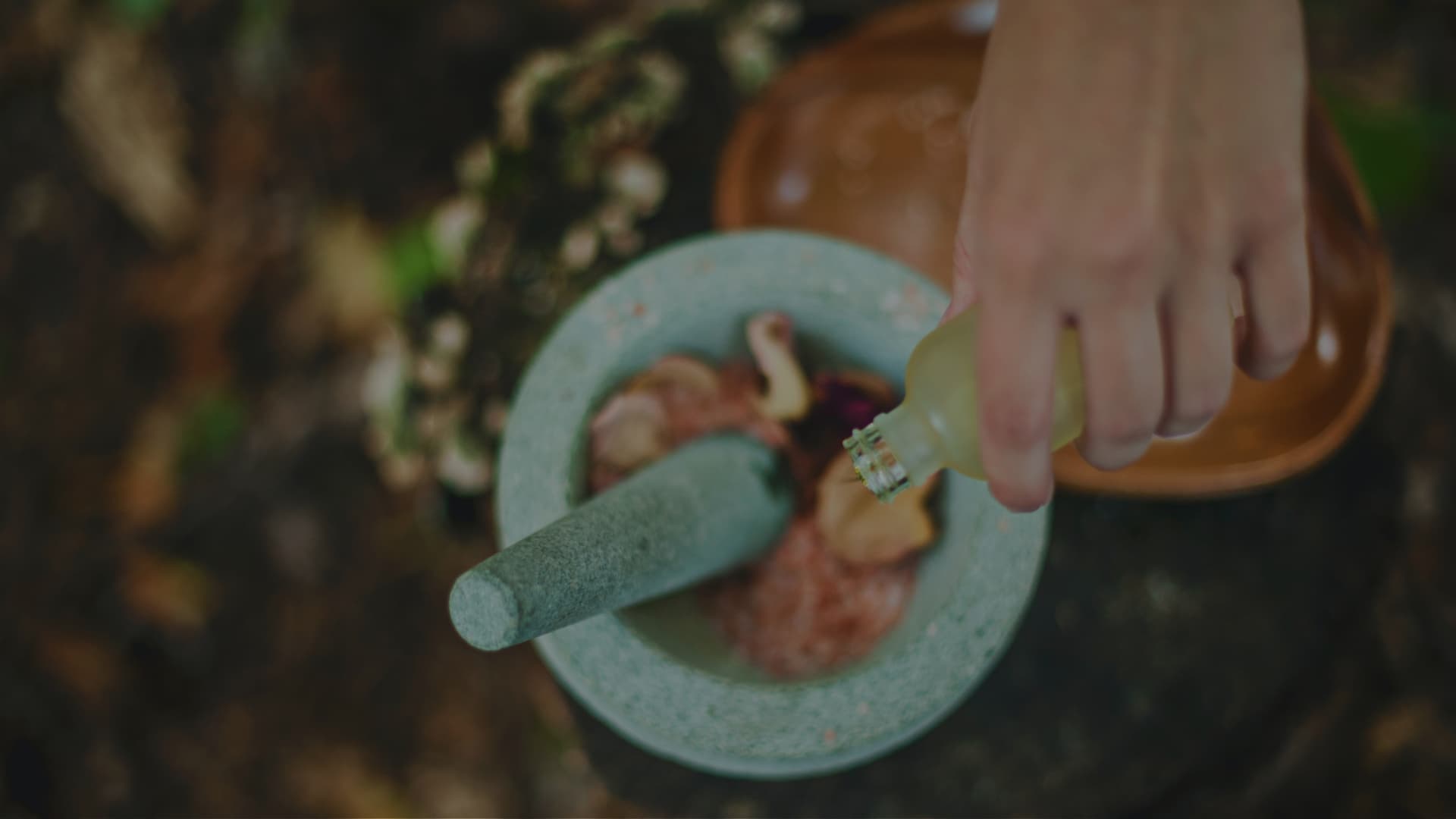 Herbal ingredients being prepared in a stone mortar