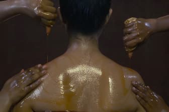 Warm medicated oil used for a Pizhichil treatment