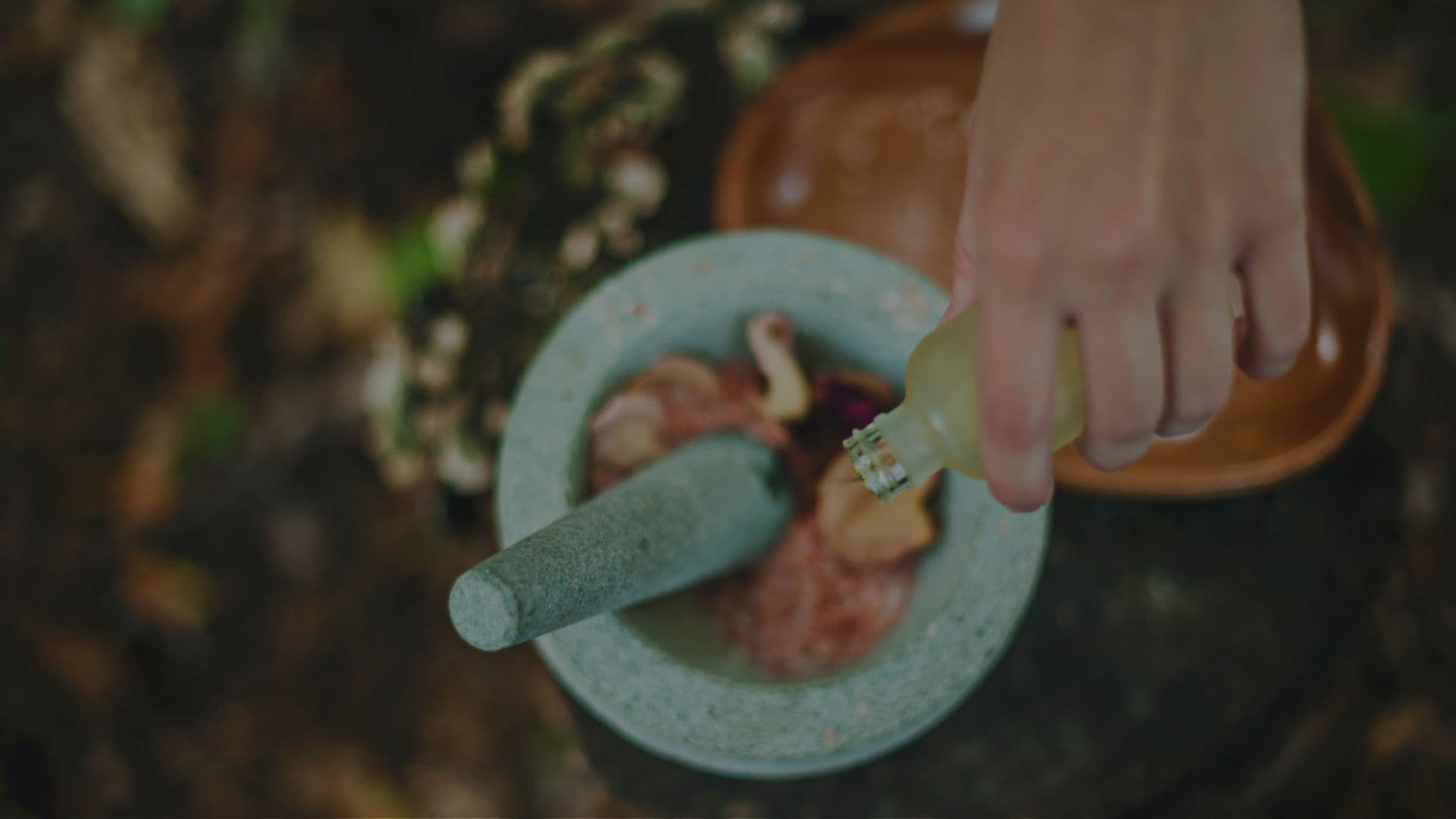 Herbal ingredients being prepared in a stone mortar